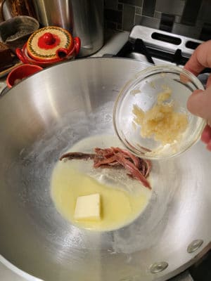 Adding garlic to pan.