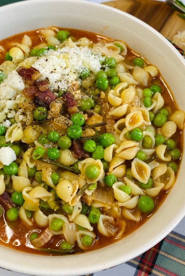 Finished pasta e piselli is styled in bowl.