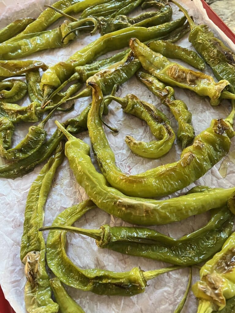 Roasted long hots on parchment-lined sheet pan after being removed from oven.