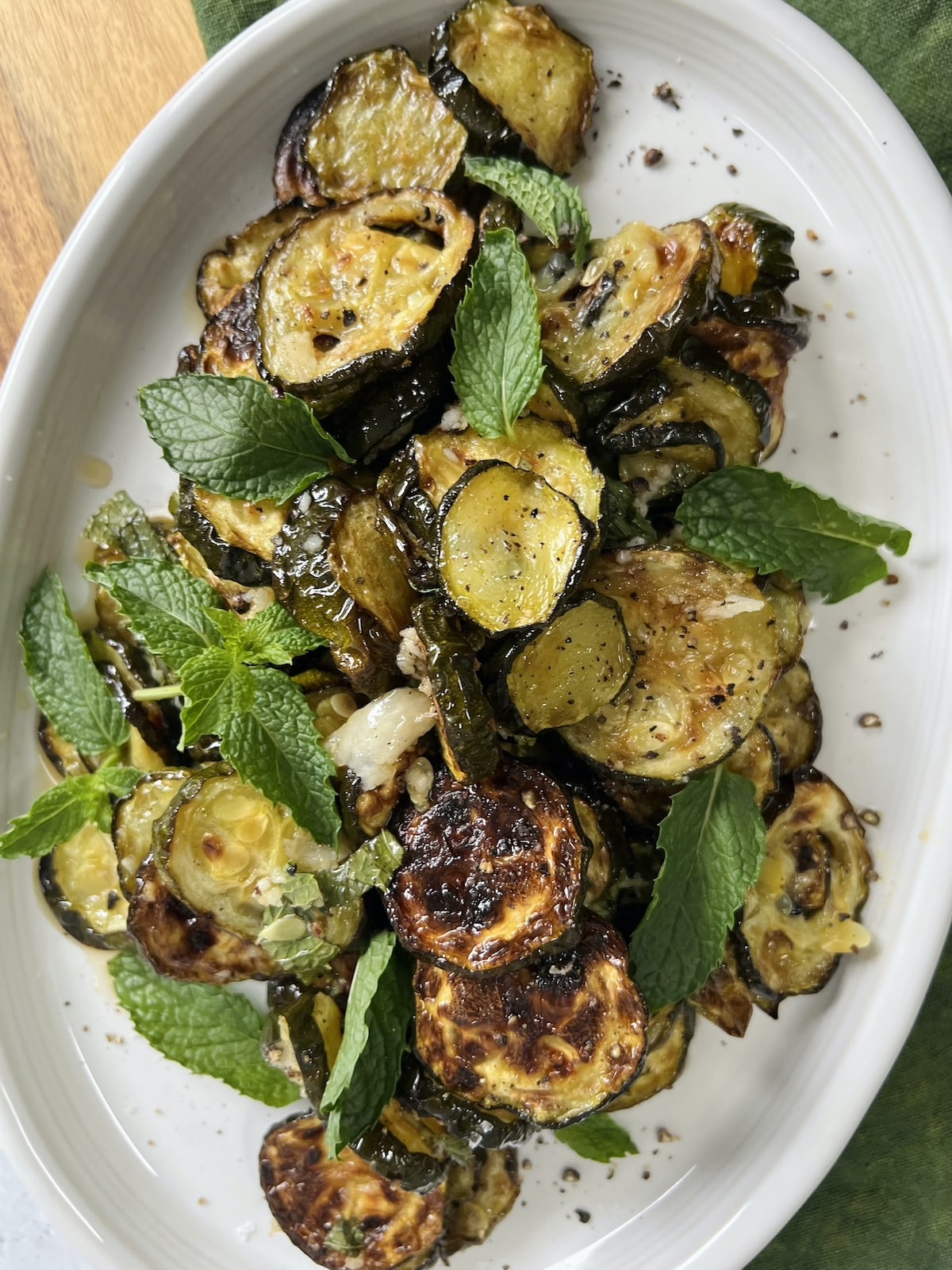 Zucchini alla scapece styled on white platter with fresh mint.