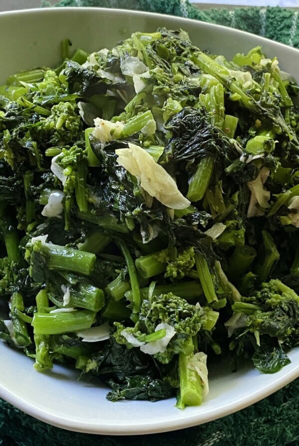Finished sautéed rapini in white bowl.