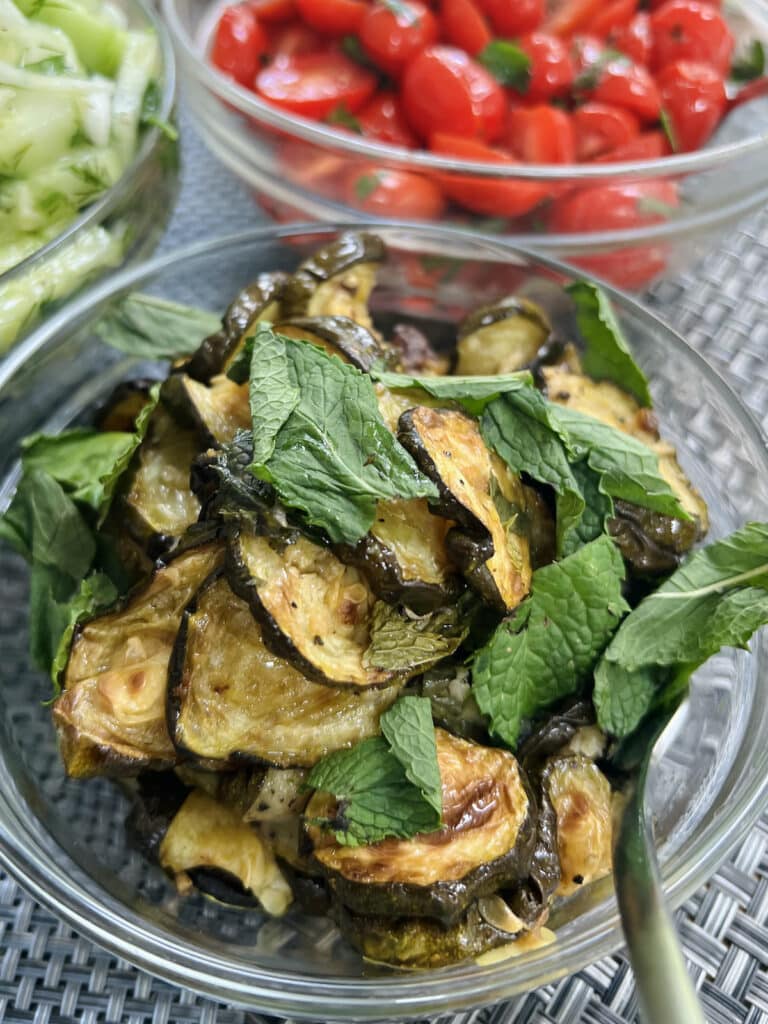 Zucchini alla scapece in bowl with mint garnish.