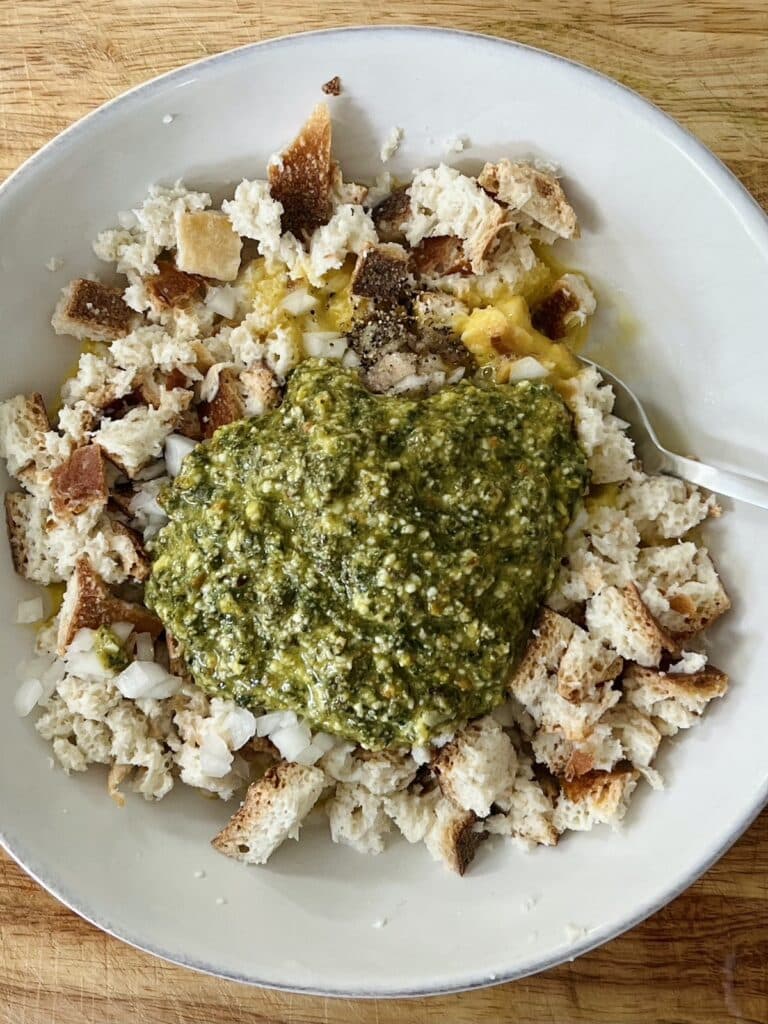 Bowl with pesto and other prepped ingredients about to be mixed together.