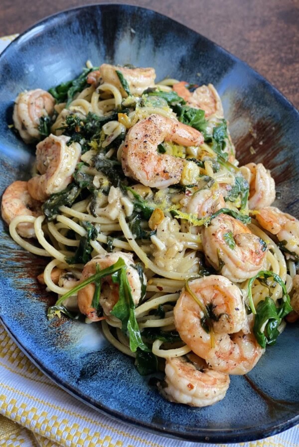 Styled Shrimp Arugula Pasta on blue platter.