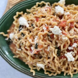 Overhead view of fusilli sorrentina on green platter. with fork in pasta.