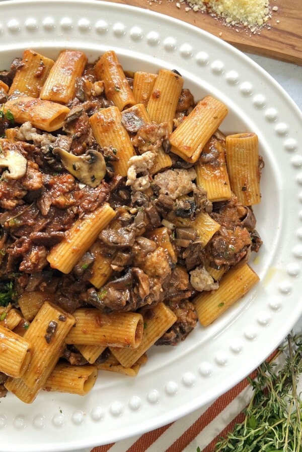 Overhead view of boscaiola pasta in white platter.
