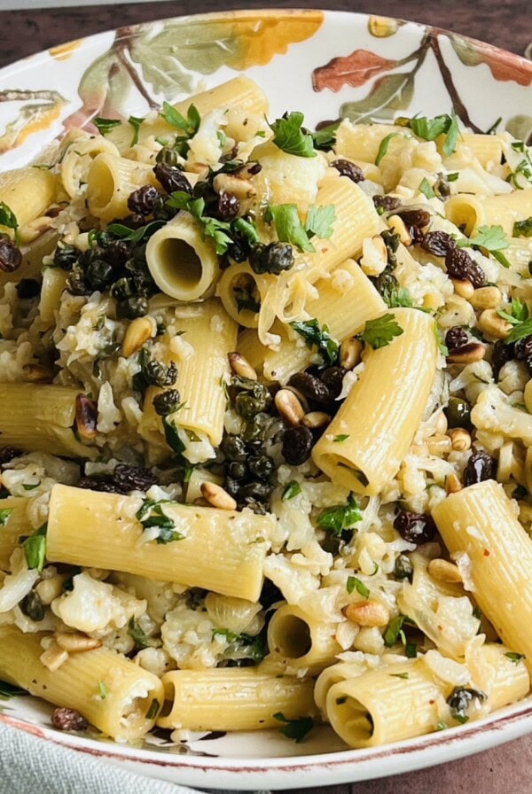 Finished Sicilian pasta with cauliflower in pretty white bowl.