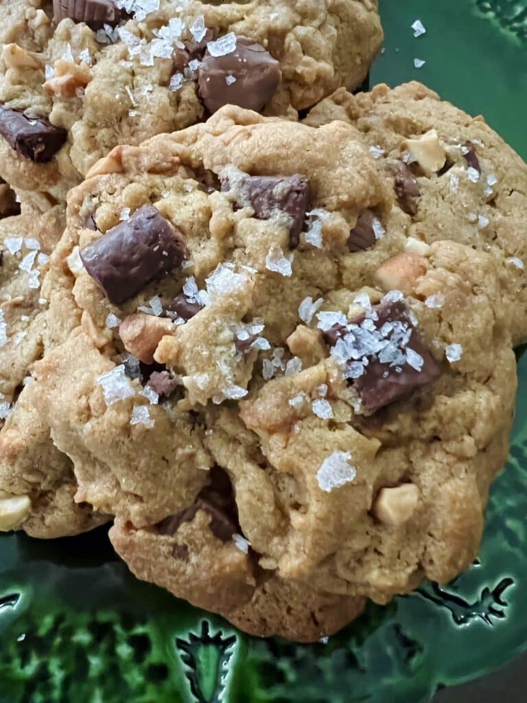 Close up of Peanut Butter Cup Chocolate Chip Cookies with large pieces of flaky sea salt.