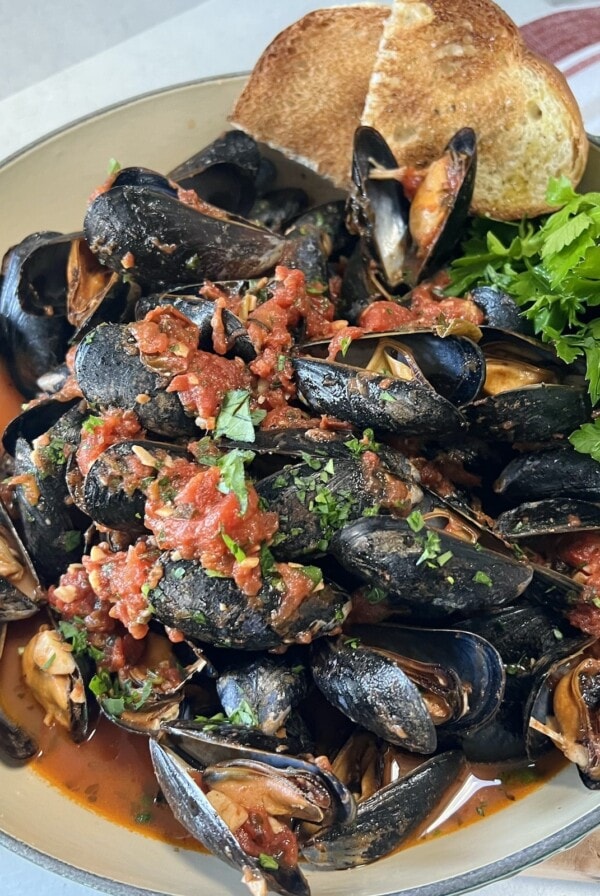Finished mussels marinara with parsley and toasted bread.