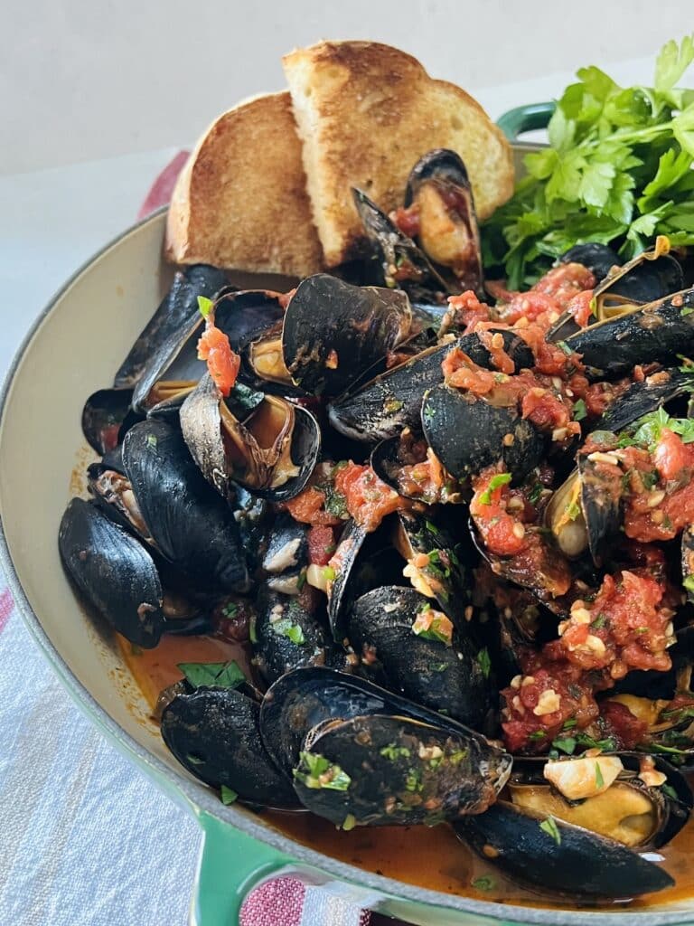 Finished mussels marinara with parsley and toasted bread.