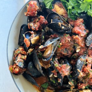 Finished mussels marinara with parsley garnish.