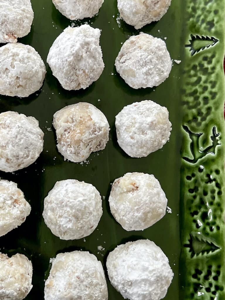 Close up of Pecan Snowball Cookies on green dish.