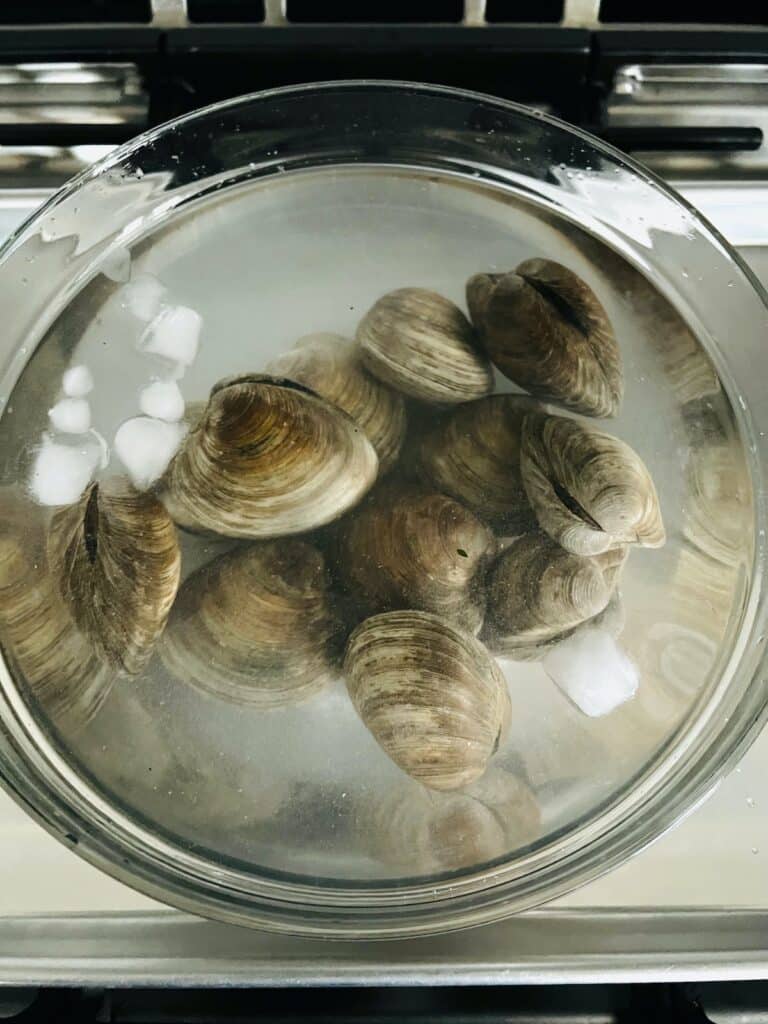 Clams immersed in salted water to purge them of trapped sand.