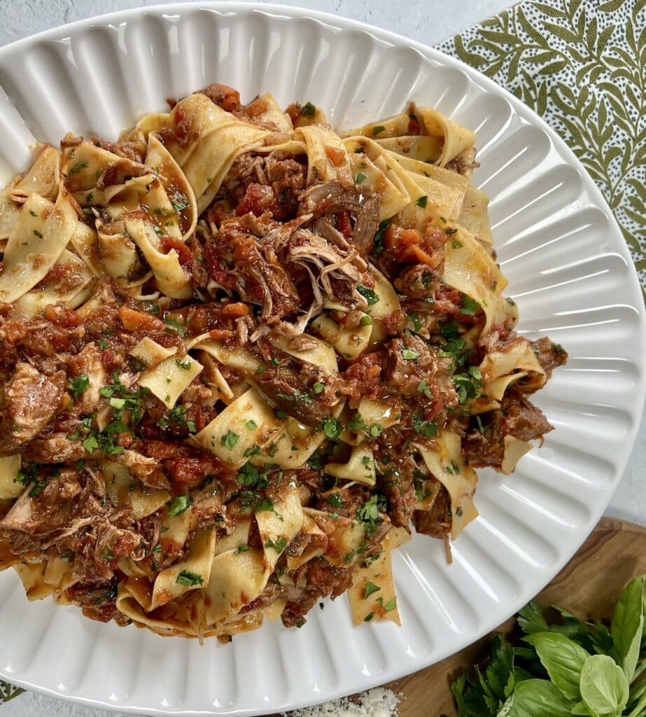 Finished pappardelle with pork ragu recipe in pan on white platter.