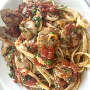 Authentic Italian Red Clam Sauce with Linguine styled in white bowl.