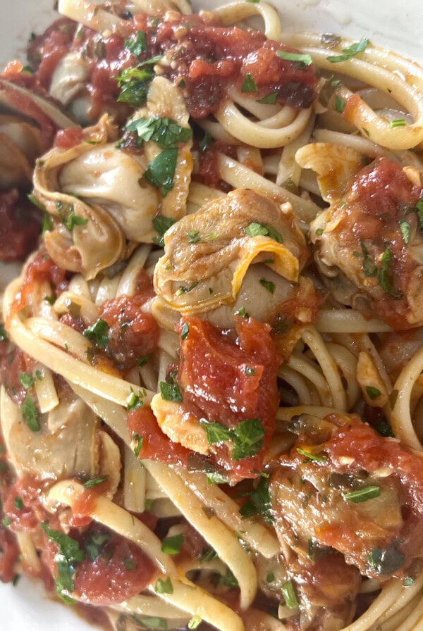 Authentic Italian Red Clam Sauce with Linguine styled in white bowl.