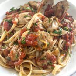 Authentic Italian Red Clam Sauce with Linguine styled in white bowl.