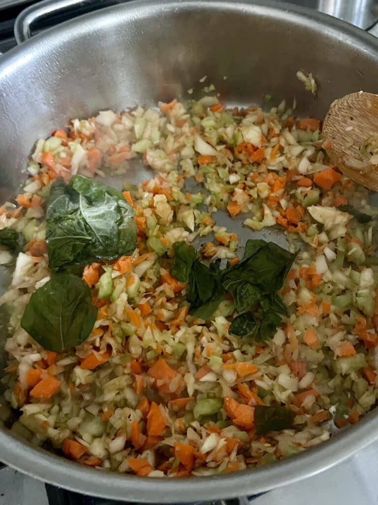 Sautéing vegetables and basil in olive oil.