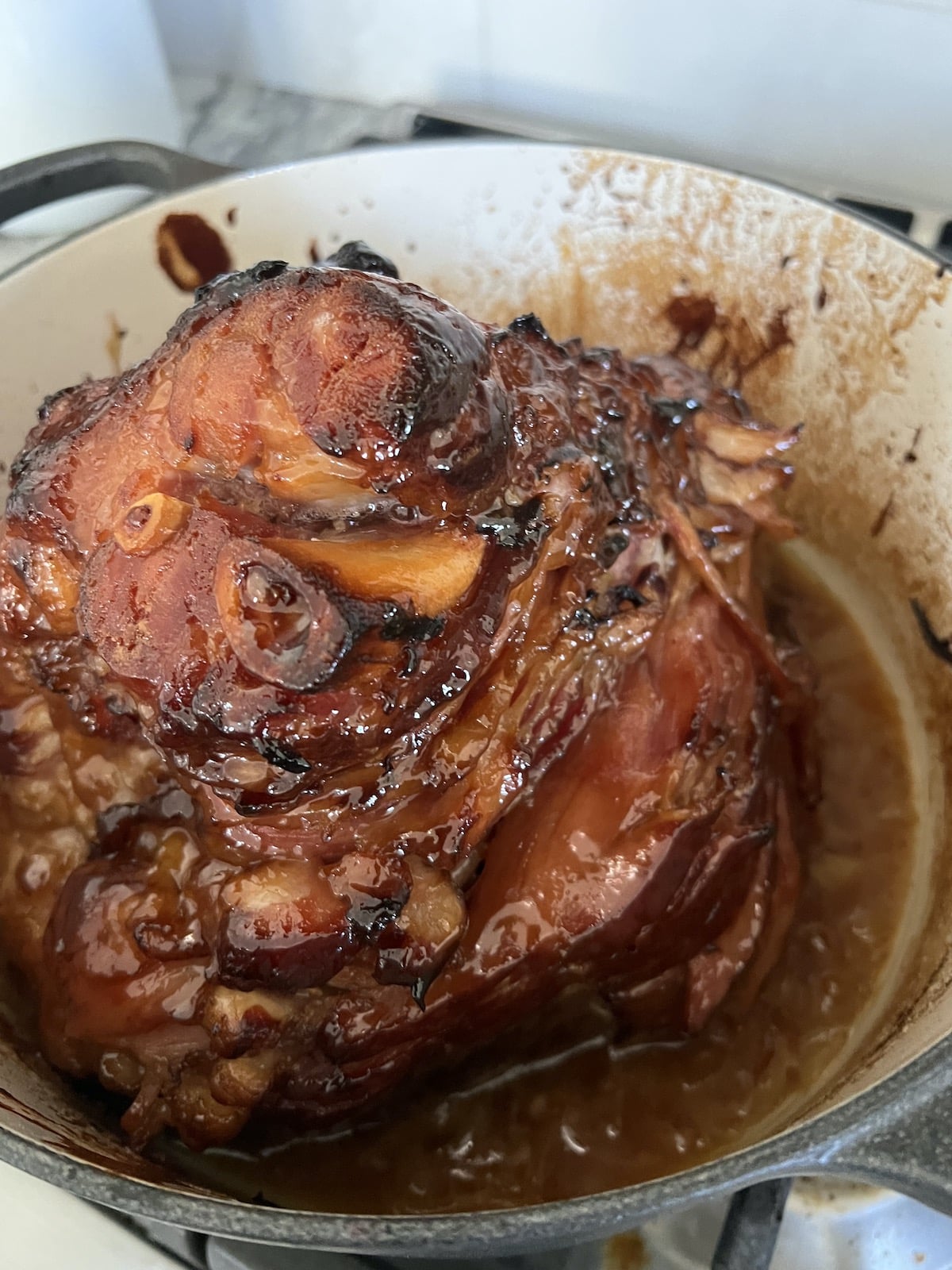 Baked glazed ham in Dutch oven ready to carve and serve.