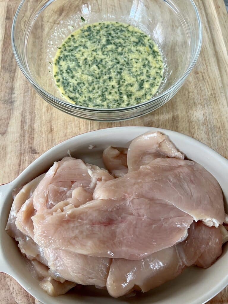 Bowl of seasoned egg mixture next to a plate of prepped chicken cutlets.