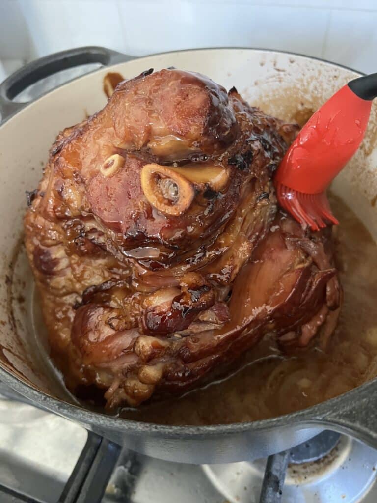 Brushing the spiral ham with marsala glaze.