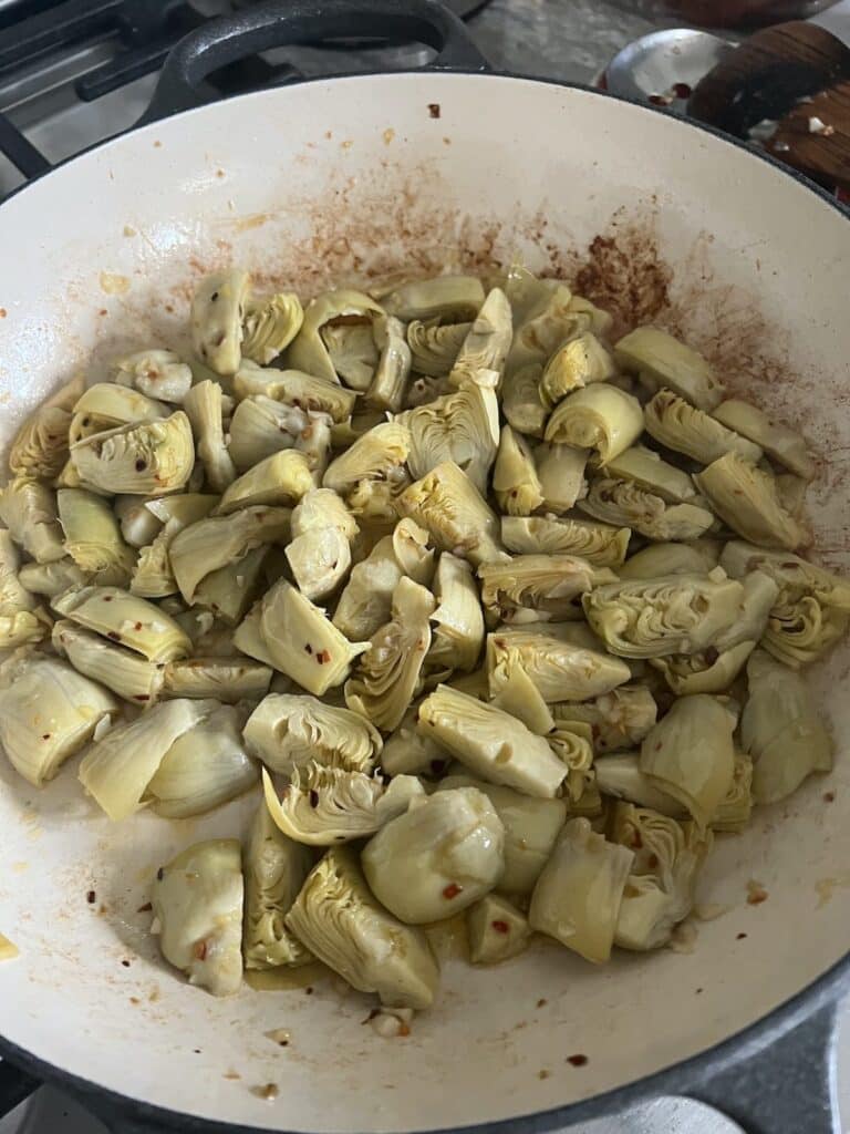 Sautéing artichoke hearts in pan.