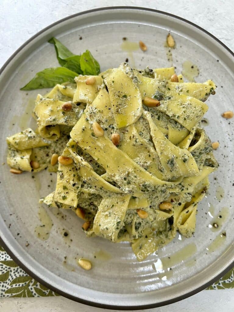 Plated pesto ricotta pasta with basil garnish.