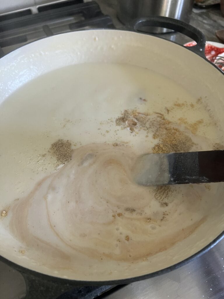 Mixing seasonings into white sauce/bechamel.