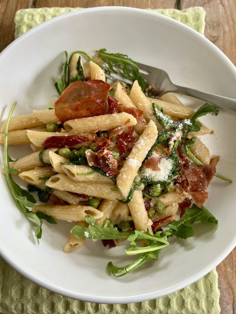 Crispy prosciutto pasta in white pasta bowl.