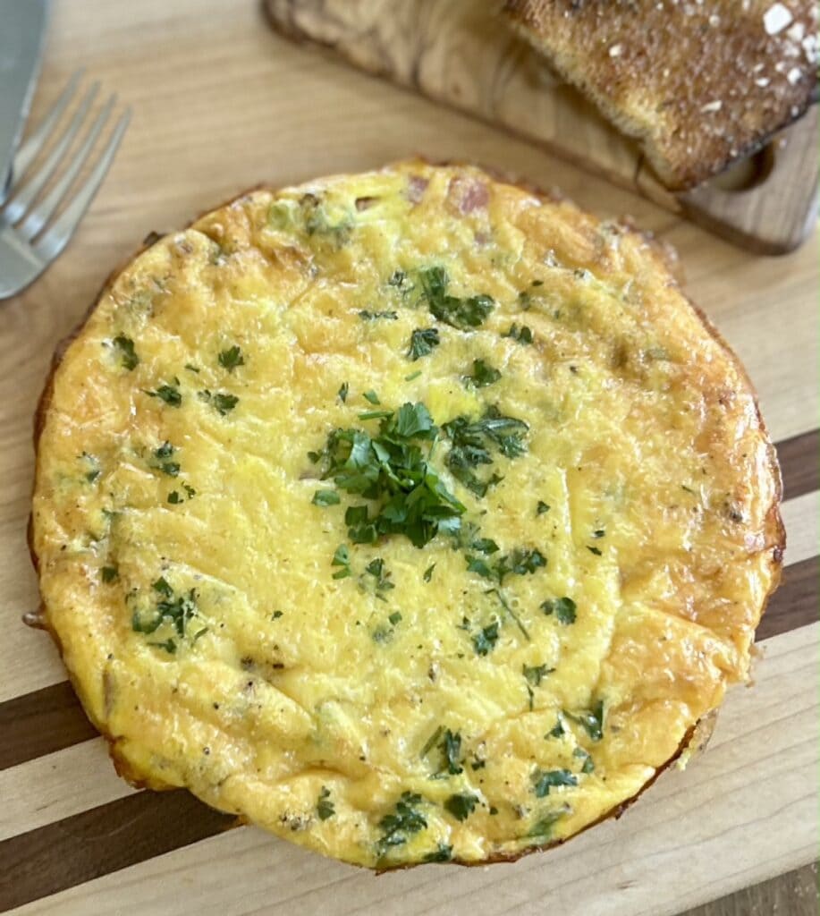 Finished egg frittata released from pan on cutting board.