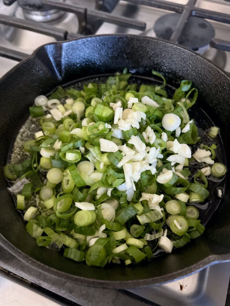 Sautéing green onions in butter in cast iron pan.