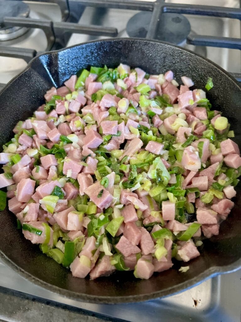 Sautéing green onions and ham in cast iron pan.