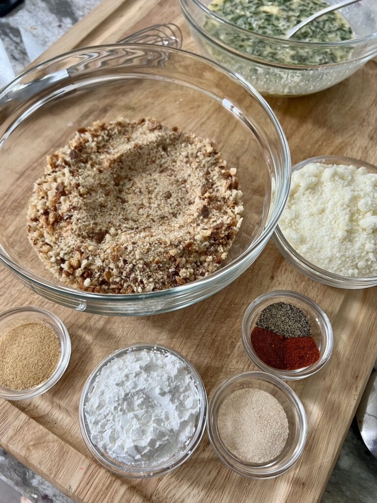 All ingrdients to make the seasoned breadcrumbs in glass bowls on cutting board.