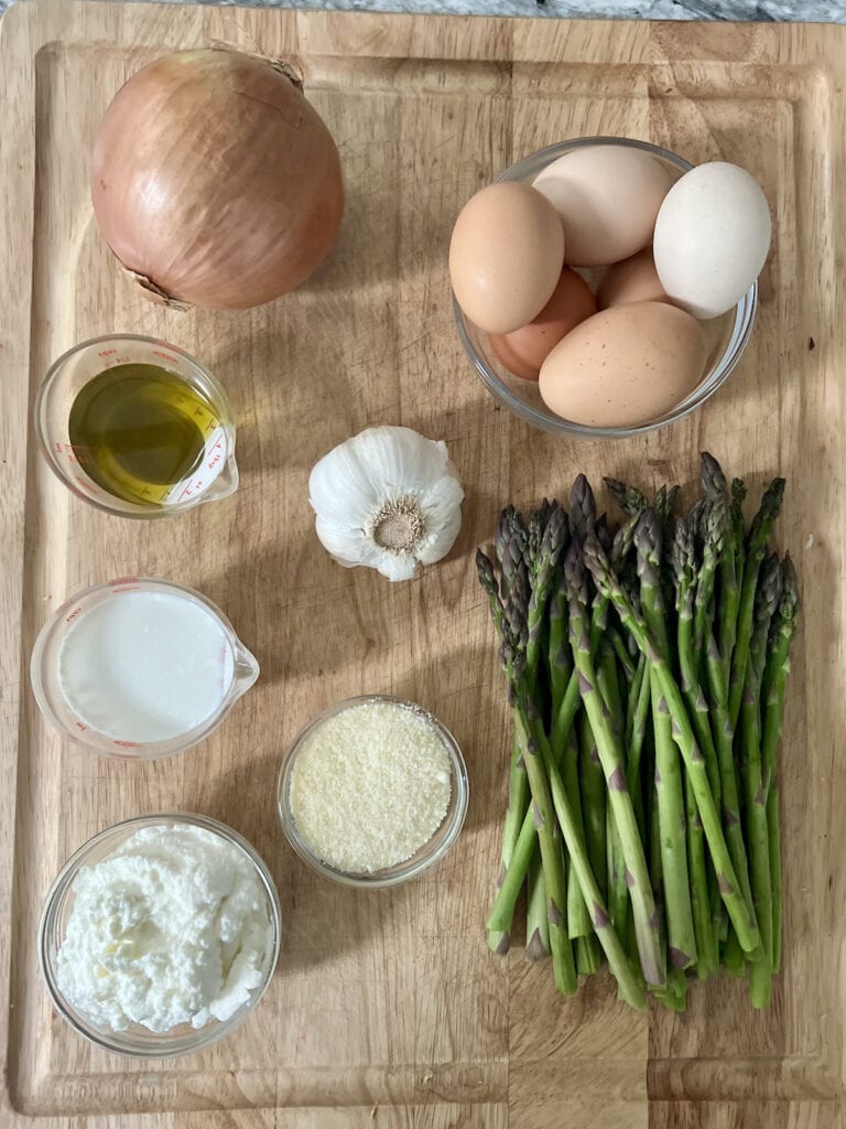 Main ingredients for asparagus and eggs recipe on cutting board.