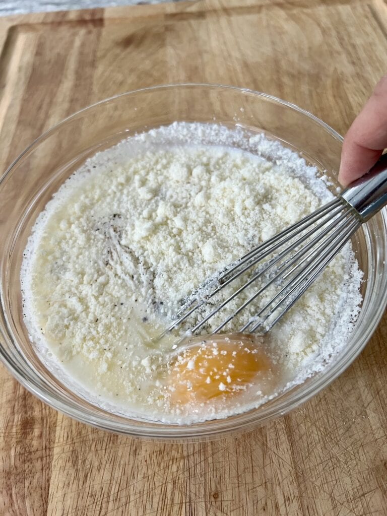Whisking the egg mixture in a glass bowl.