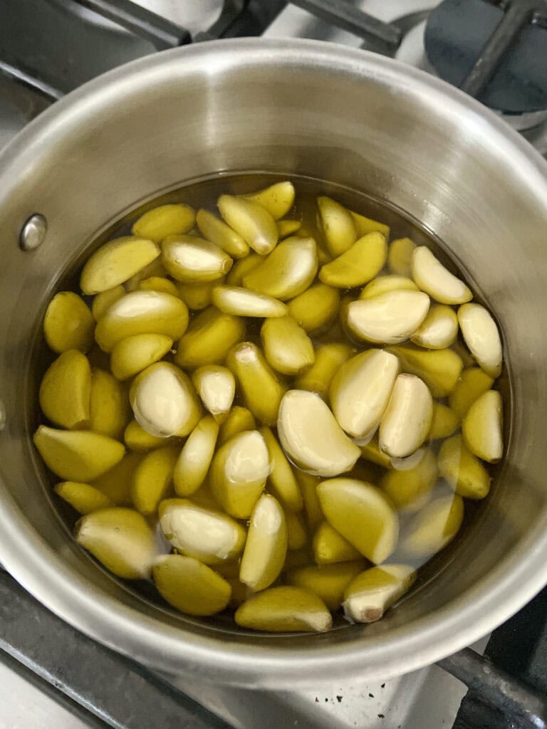 Making garlic confit in pot.