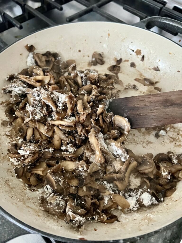 Mixing flour into cooked mushrooms.