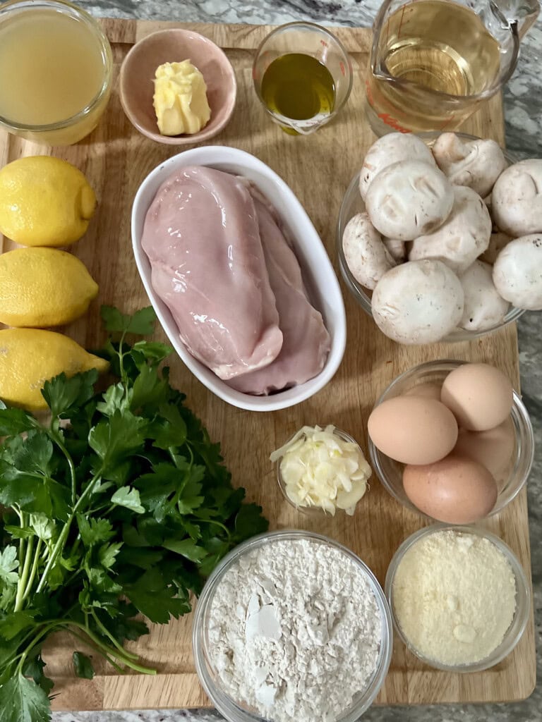 Ingredients for italian chicken francese with mushrooms on cutting board.