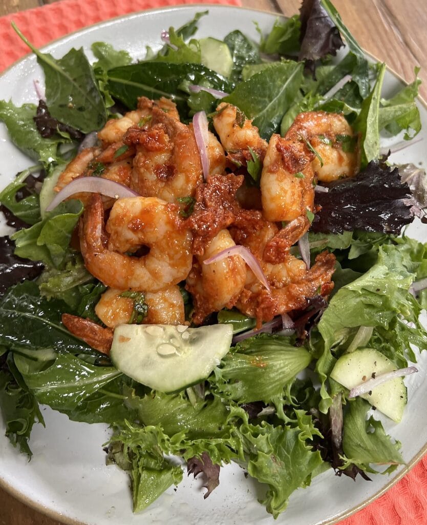 Spicy tomato shrimp over a mixed green salad.
