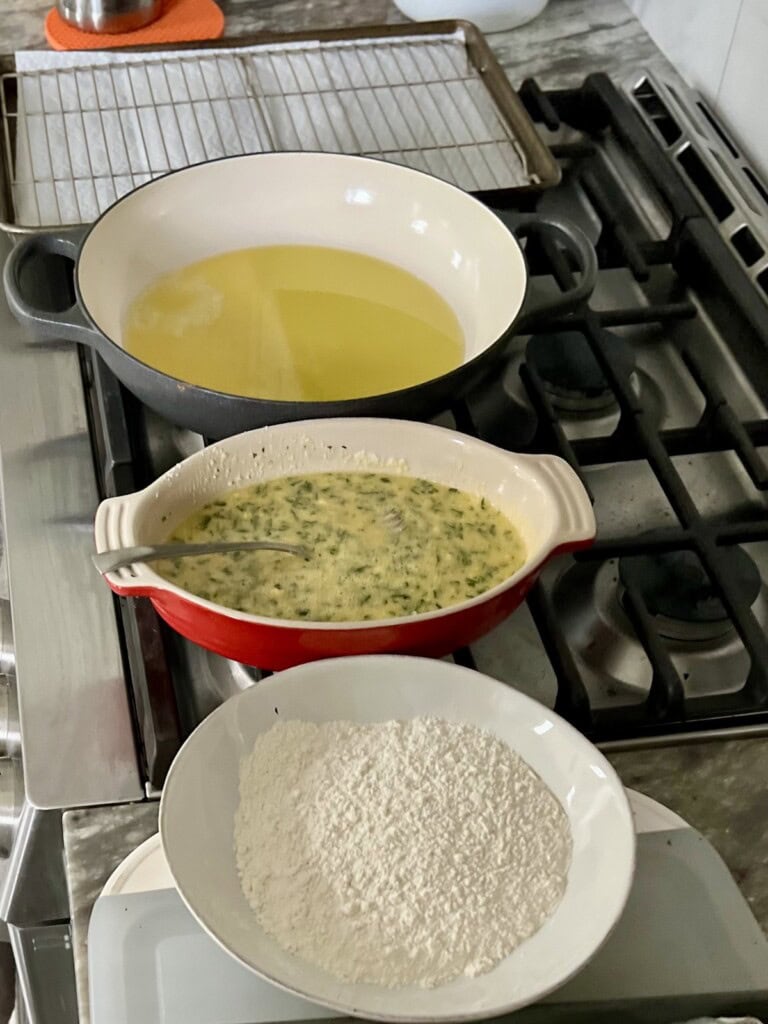 Batter line up of flour, then egg mixture, then pan then rack and sheet pan landing station.