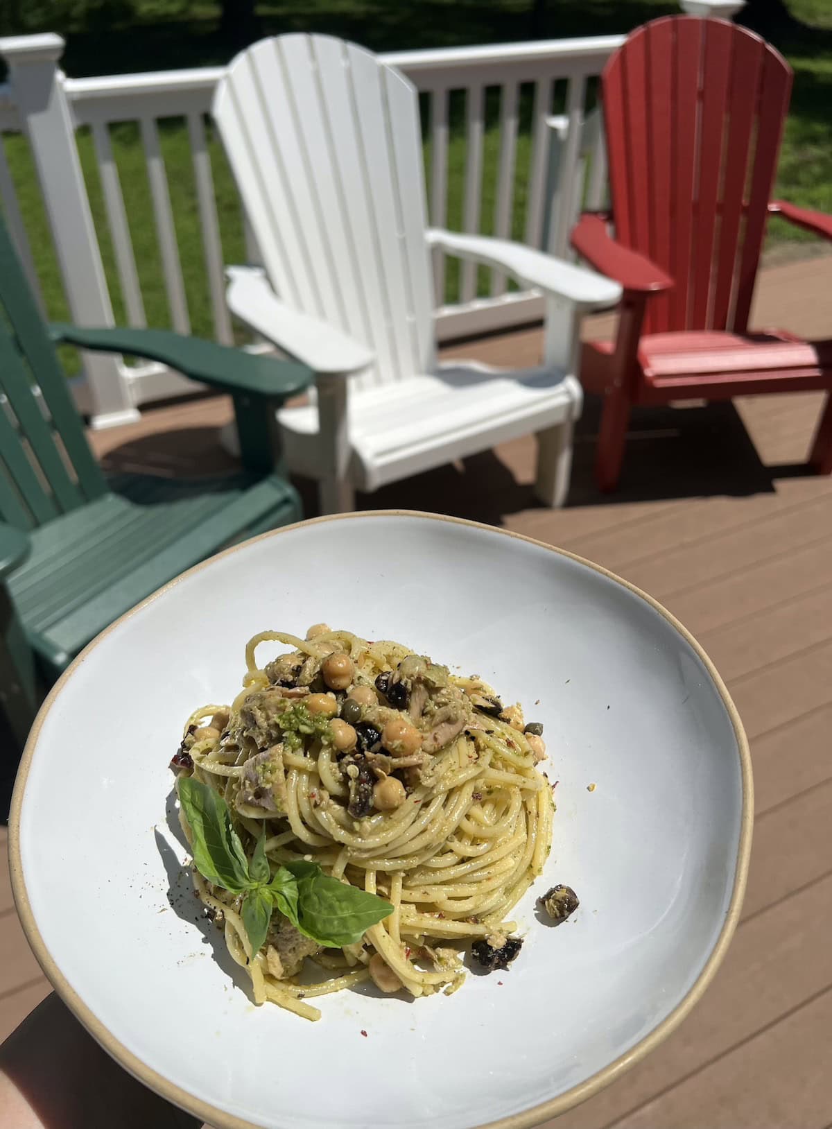 Plateful of tuna pesto pasta with deck chairs in background.