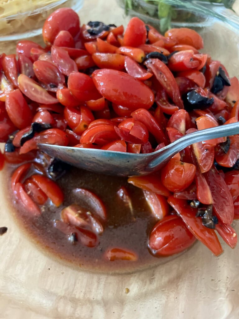 Checking the tomato juice/sauce that develops after the tomato mixture rests awhile by pushing some tomatoes aside with a spoon.