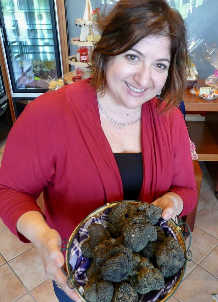 Michele holding a large bowl of black truffles in Italy.