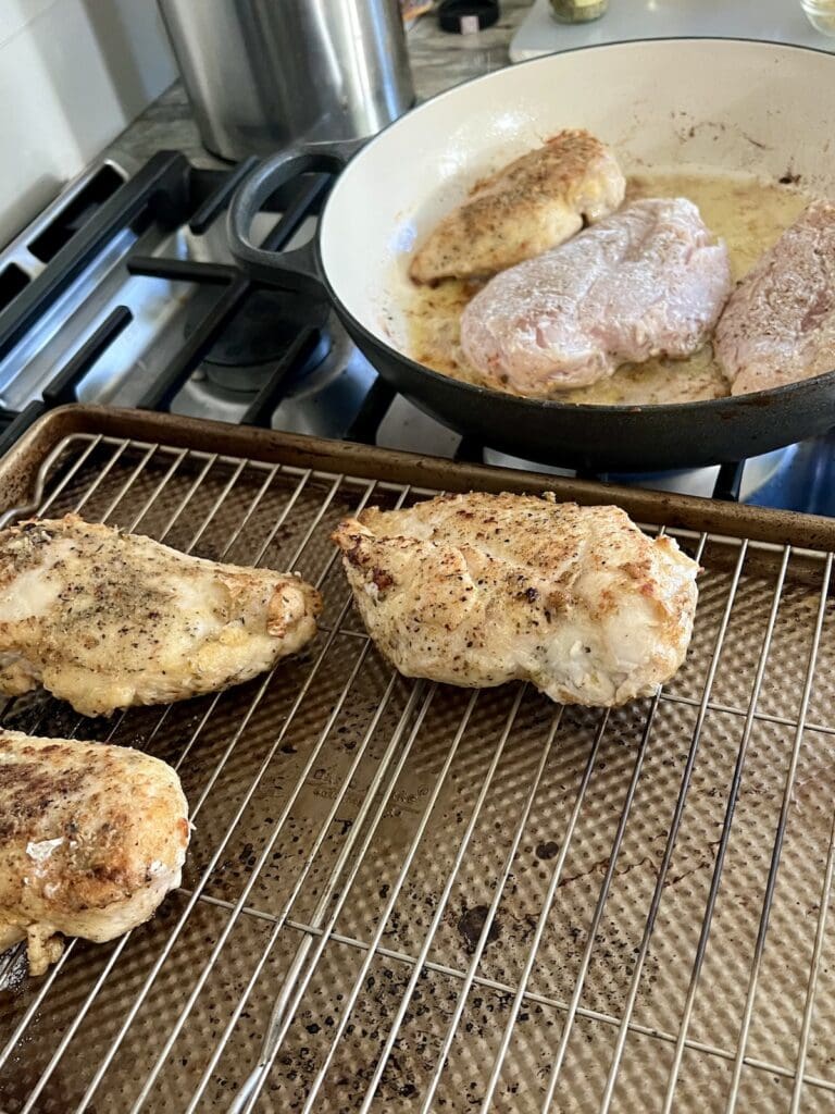 Browned chicken for chicken with tomatoes recipe on baking rack after being seared.