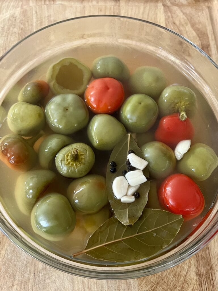 Vinegar cherry peppers in brine in glass bowl.