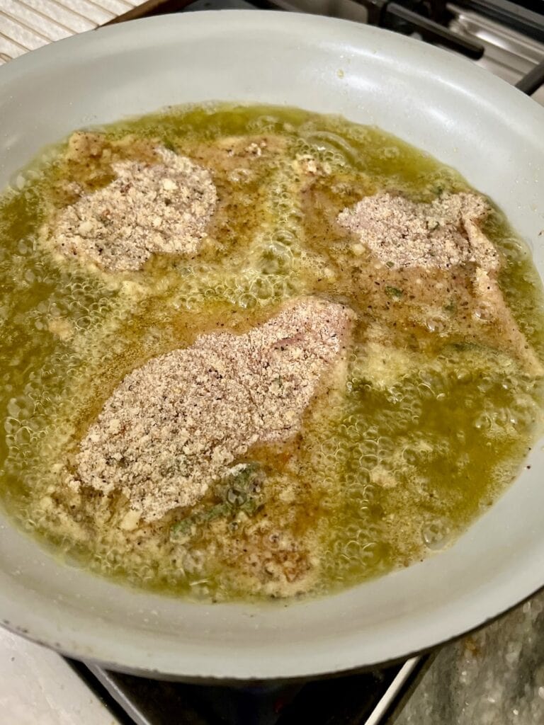 Pan-frying pork Milanese in frying pan.