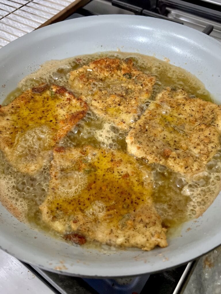 Pan-frying pork Milanese in frying pan.