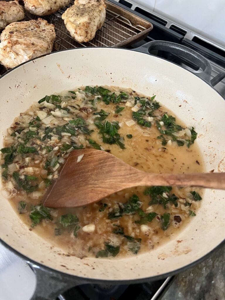 Starting the sauce for chicken pomodoro by degalzing the pan with white wine after sauteing some aromatics.