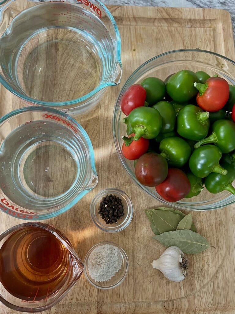 All ingredients for Pickled Cherry Bomb Peppers on cutting board.