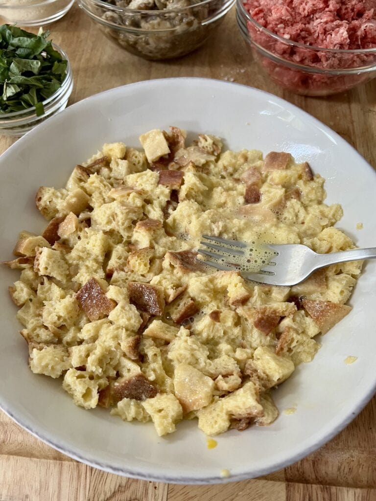 Pressing the bread and egg/milk mixture down with a fork to make sure all bread is immersed.